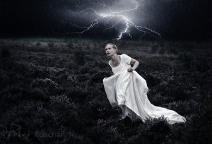 Vrouw rent over de heide in een onweersbui.